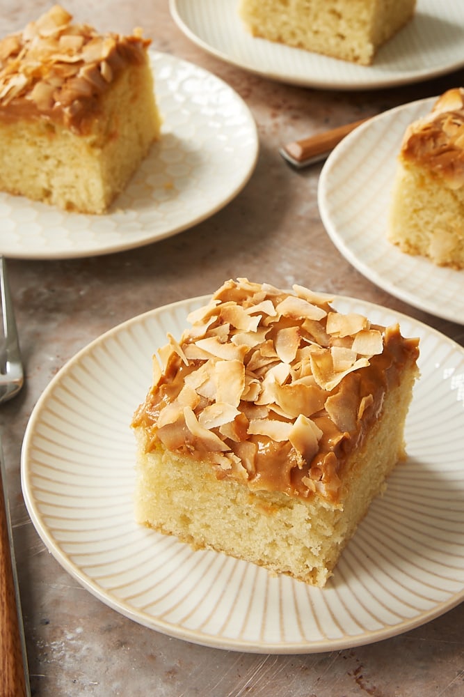 slices of Coconut Cake with Dulce de Leche Frosting on white and beige plates