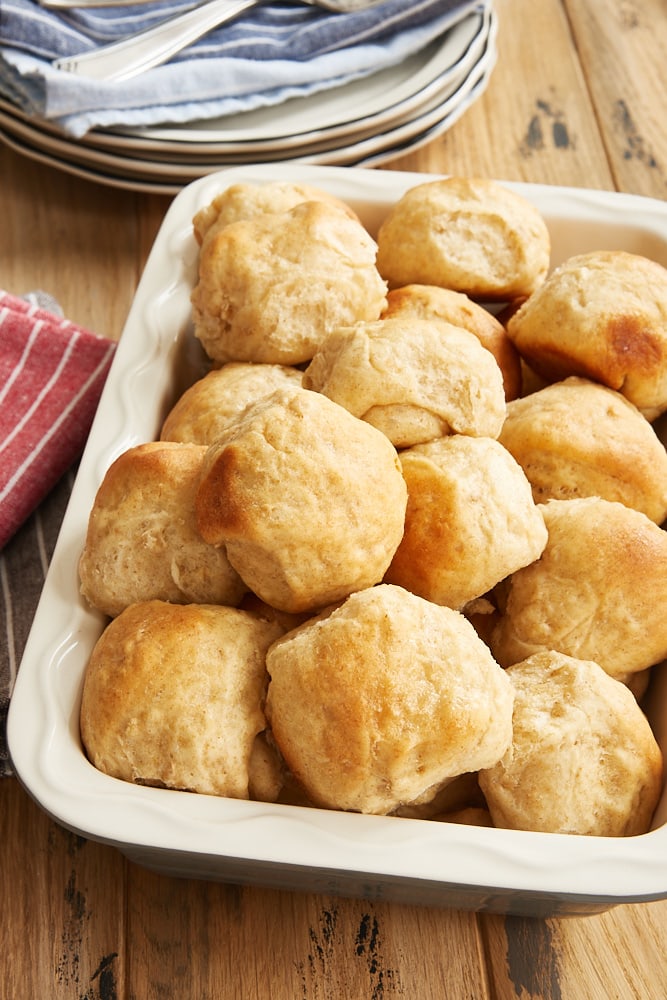 Honey Oat Rolls in a serving dish on a wooden surface