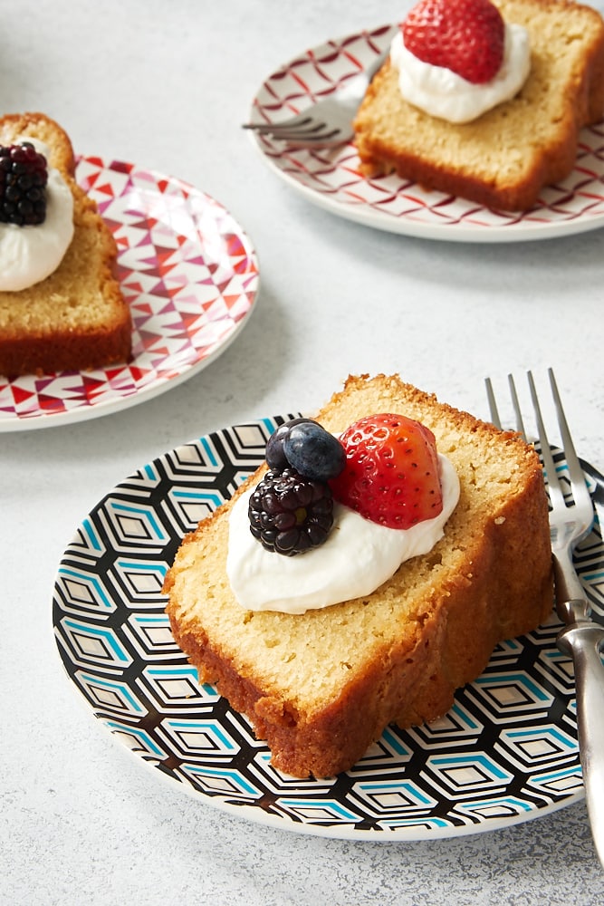 slice of Sour Cream Pound Cake topped with sweetened whipped cream and fresh berries