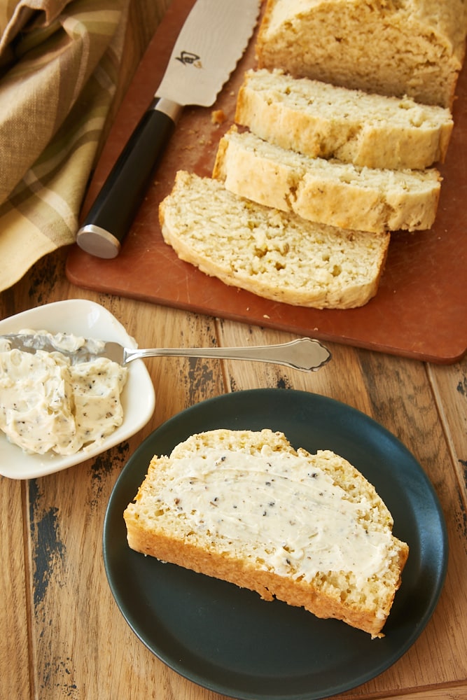 slice of Easy Herbed Quick Bread spread with garlic compound butter