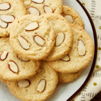 overhead view of Almond Cookies on a white and brown speckled plate
