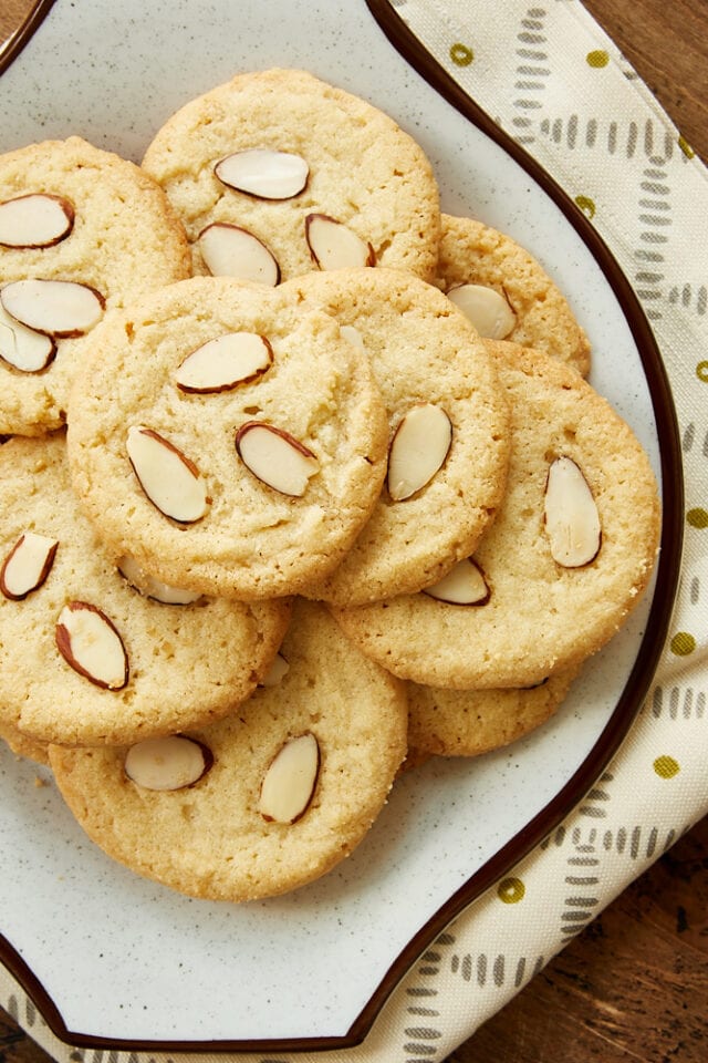 overhead view of Almond Cookies on a white and brown speckled plate