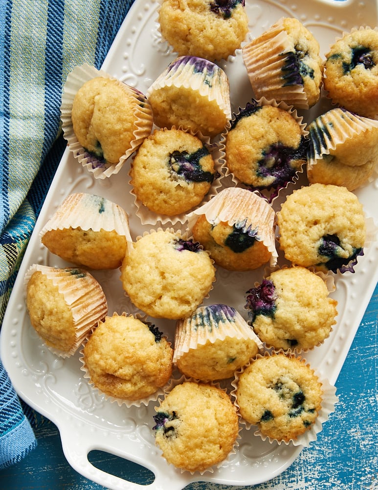 A white tray piled with Blueberry Sour Cream Mini Muffins.