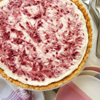 No-Bake Raspberry Cheesecake on a milk glass stand