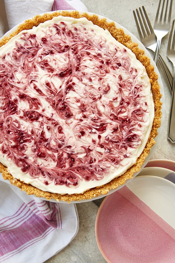 No-Bake Raspberry Cheesecake on a milk glass stand