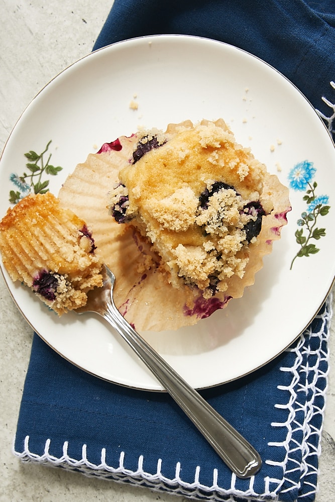 overhead view of a Blueberry Coffee Cake Muffin on a white plate with a blue floral edge