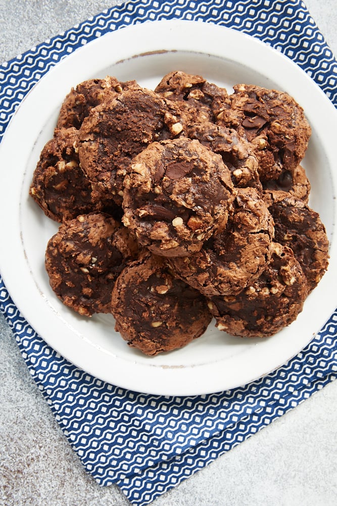 overhead view of Flourless Chocolate Hazelnut Cookies on a white plate on a blue and white napkin