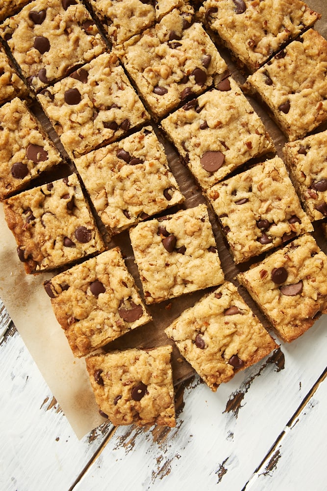 overhead view of Loaded Chocolate Chip Cookie Bars on parchment paper on a white surface