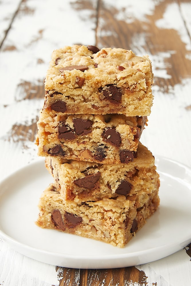 stack of Loaded Chocolate Chip Cookie Bars on a white plate