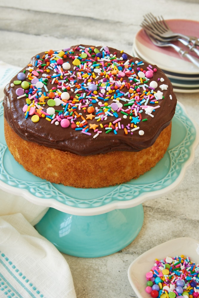 6-Inch Yellow Cake with chocolate frosting on a blue cake stand