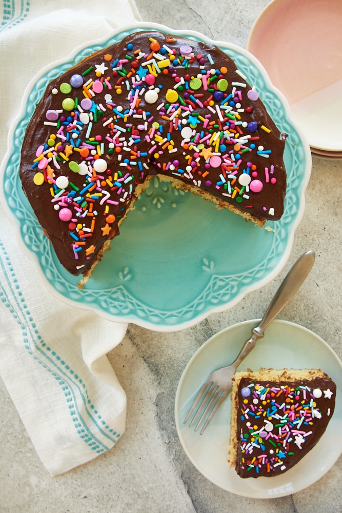 overhead view of a 6-Inch Yellow Cake on a blue cake stand and a slice of 6-Inch Yellow Cake on a blue plate