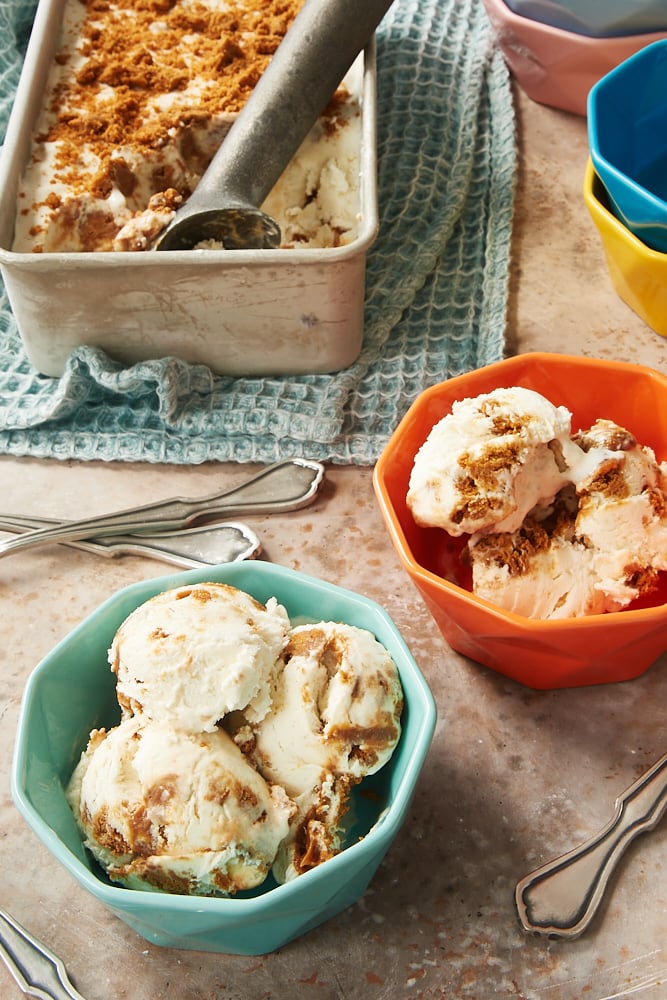 bowls of No-Churn Dulce de Leche Biscoff Ice Cream with a metal pan of remaining ice cream in the background