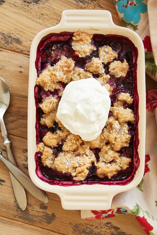 overhead view of Mixed Berry Cream Cheese Crisp topped with sweetened whipped cream