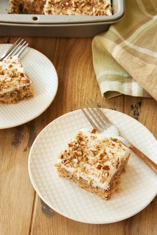 Frosted Zucchini Bars served on white and beige plates