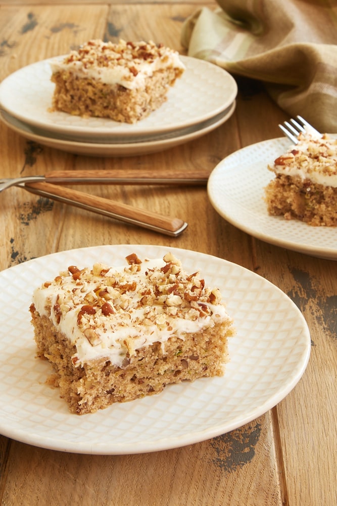 Frosted Zucchini Bars served on white and beige plates