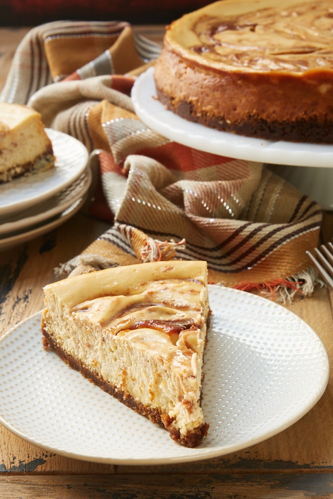 slice of Apple Butter Cheesecake on a white and beige plate