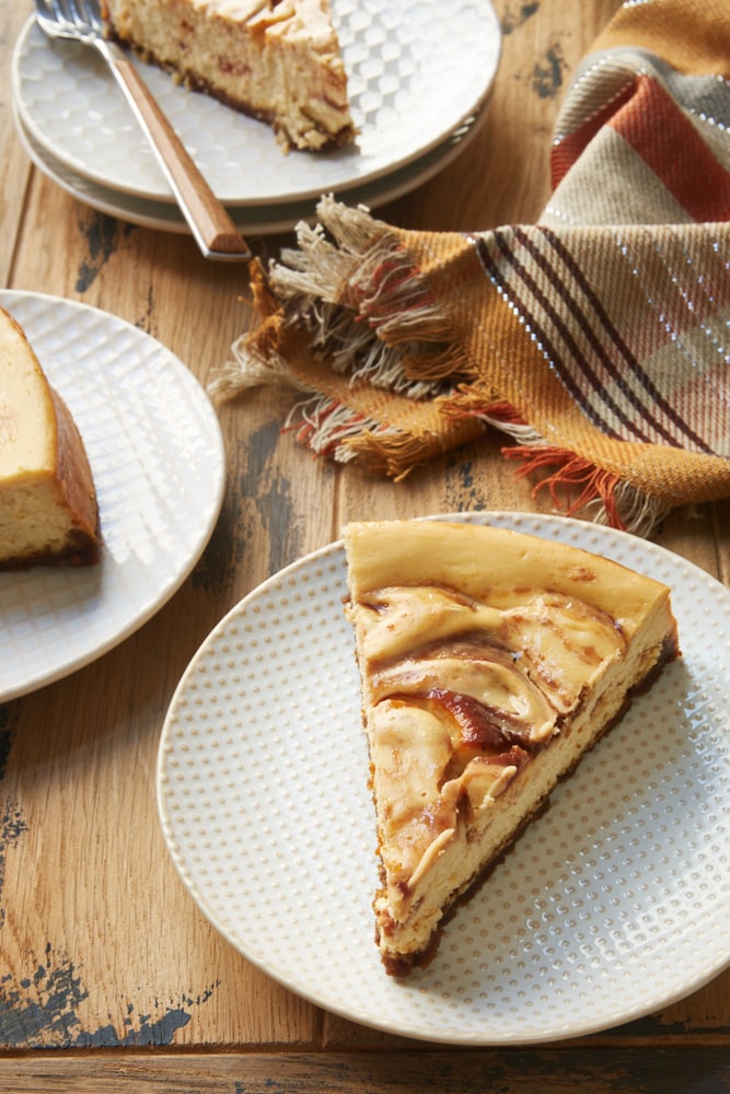 slice of Apple Butter Cheesecake on a white and beige plate