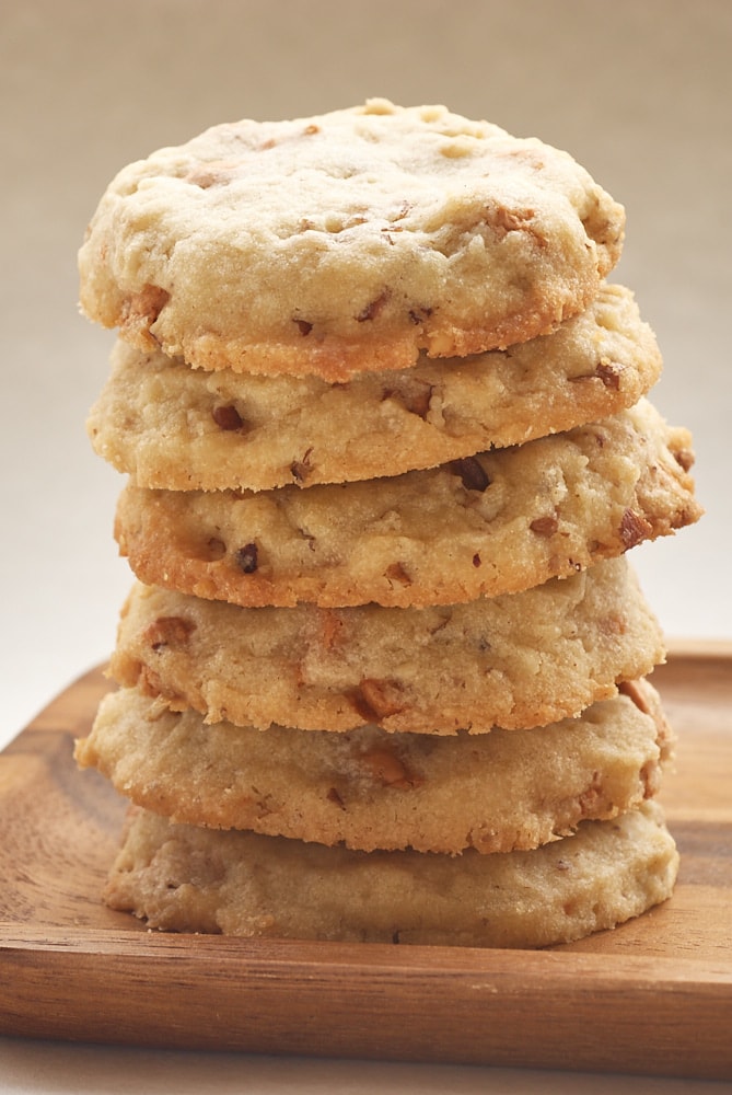 Butterscotch Pecan Sandies stacked on a small wooden plate