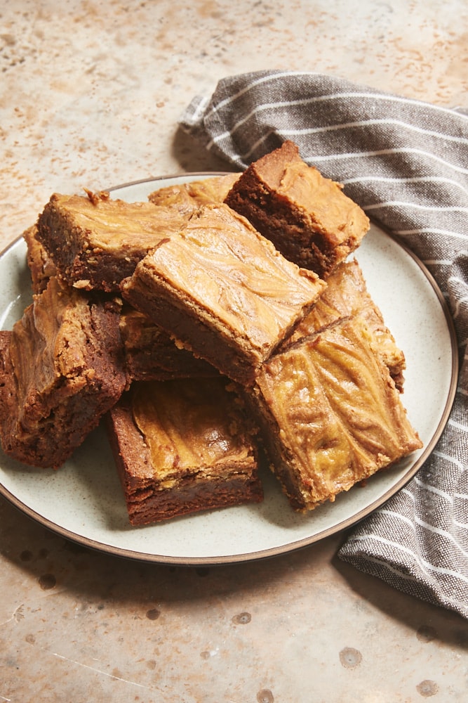 Cookie Butter Cheesecake Brownies served on a white and brown speckled plate