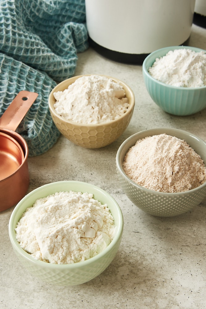 different types of flours in small colorful bowls