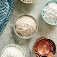 overhead view of various flours in colorful bowls
