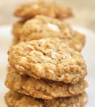 Salted Vanilla Chip Oatmeal Cookies stacked on a white plate