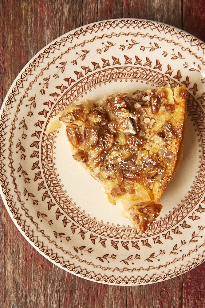 slice of Apple Bourbon Clafoutis on a brown-rimmed floral plate