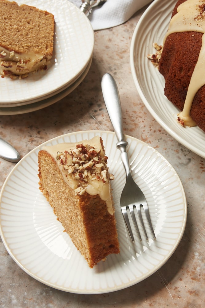 slices of Brown Sugar Spice Cake with Caramel Rum Glaze on white and beige plates