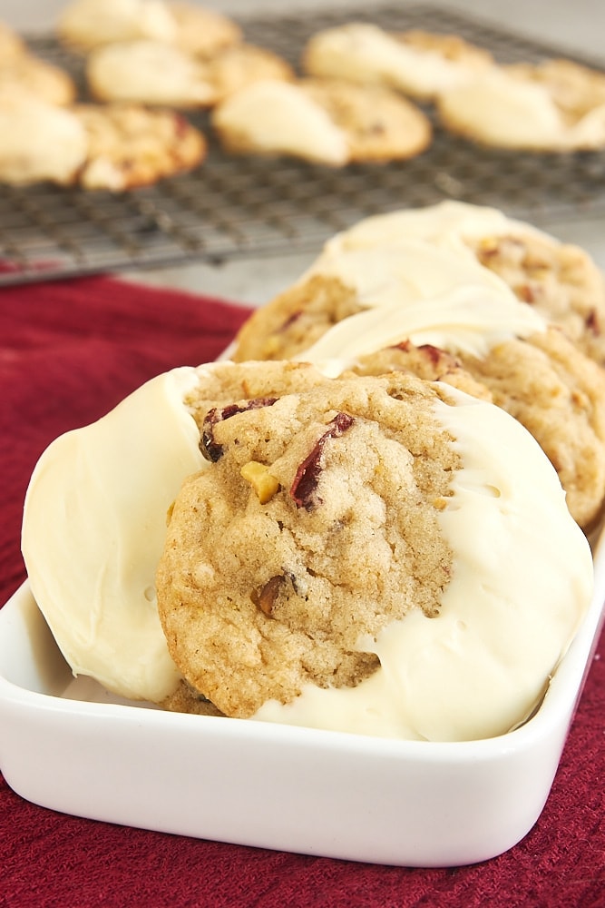 Cranberry Pistachio Cookies on a small white tray on a dark red fabric