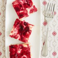 overhead view of Cranberry White Chocolate Cheesecake Bars on a white tray