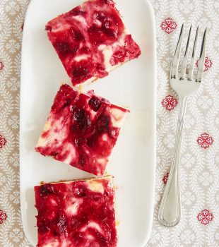 overhead view of Cranberry White Chocolate Cheesecake Bars on a white tray