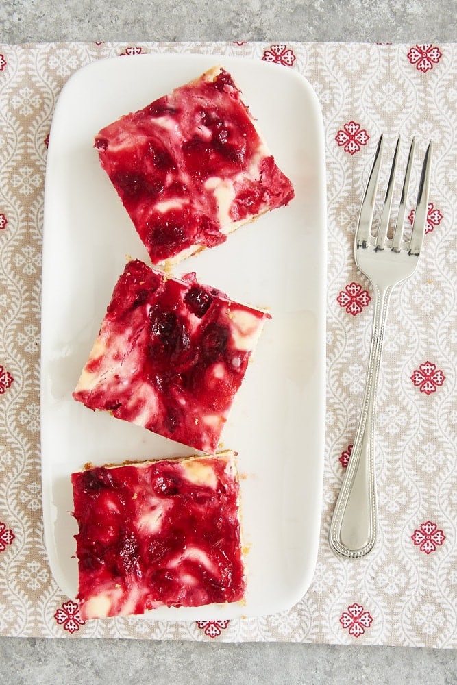 overhead view of Cranberry White Chocolate Cheesecake Bars on a white tray