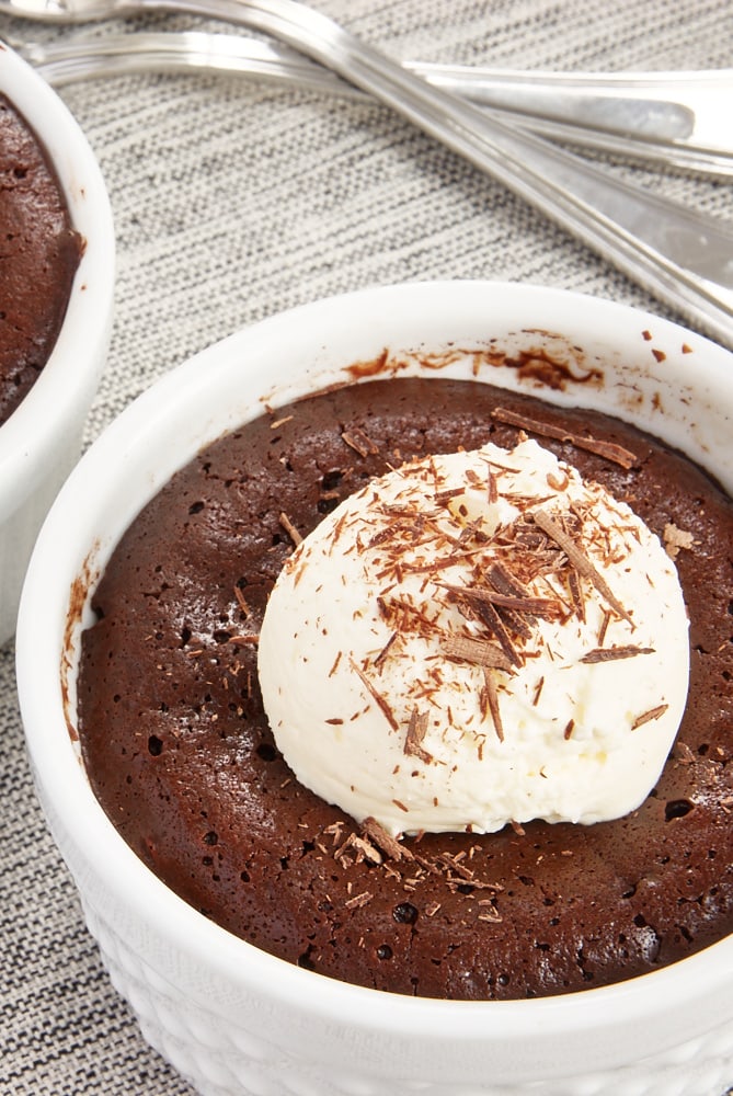 Flourless Chocolate Cakes for Two topped with whipped cream and chocolate shavings