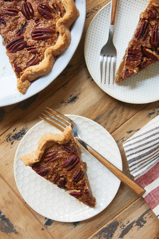 overhead view of slices of Irish Cream Pecan Pie on white and beige plates