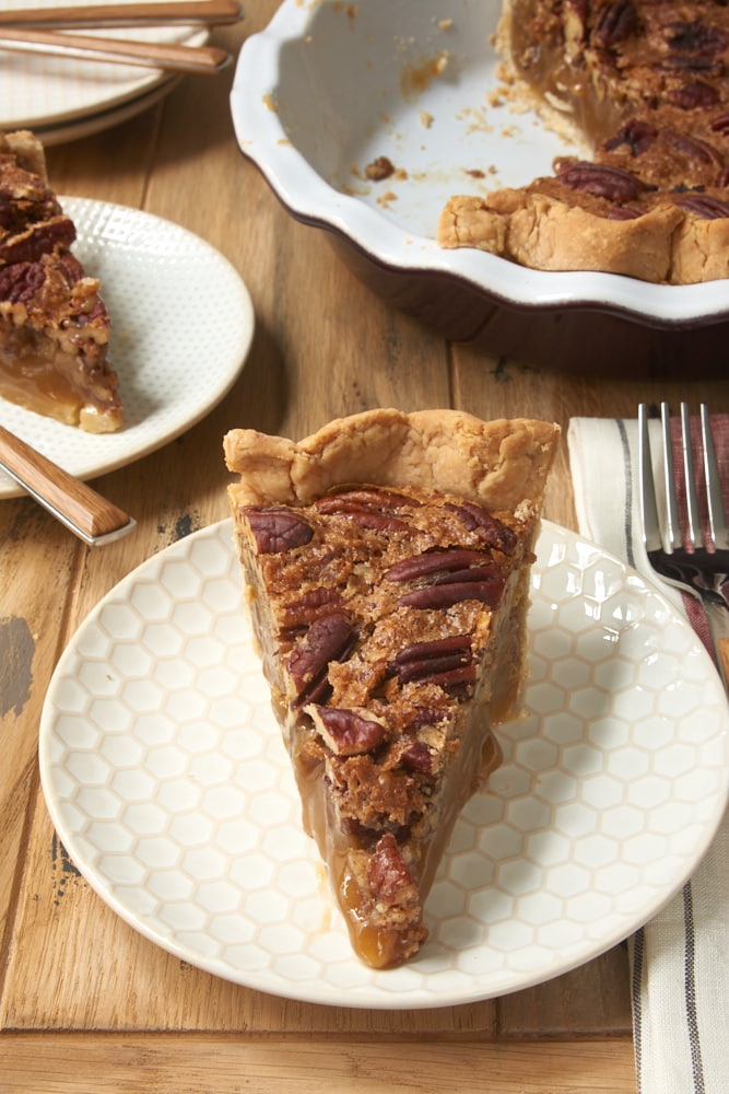 slice of Irish Cream Pecan Pie on a white and beige plate