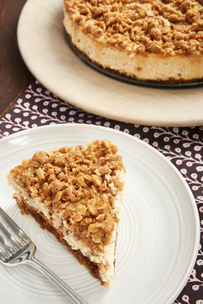 slice of Pear Crisp Cheesecake served on a pale gray plate