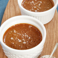 Salted Caramel Pots de Creme in white ramekins on a wooden tray