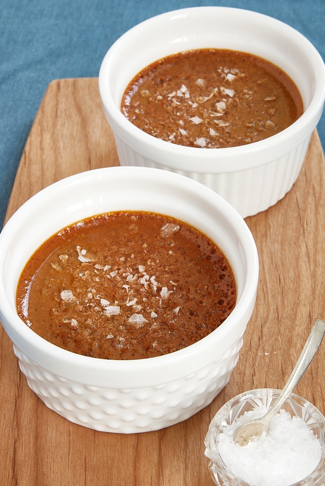 Salted Caramel Pots de Creme in white ramekins on a wooden tray