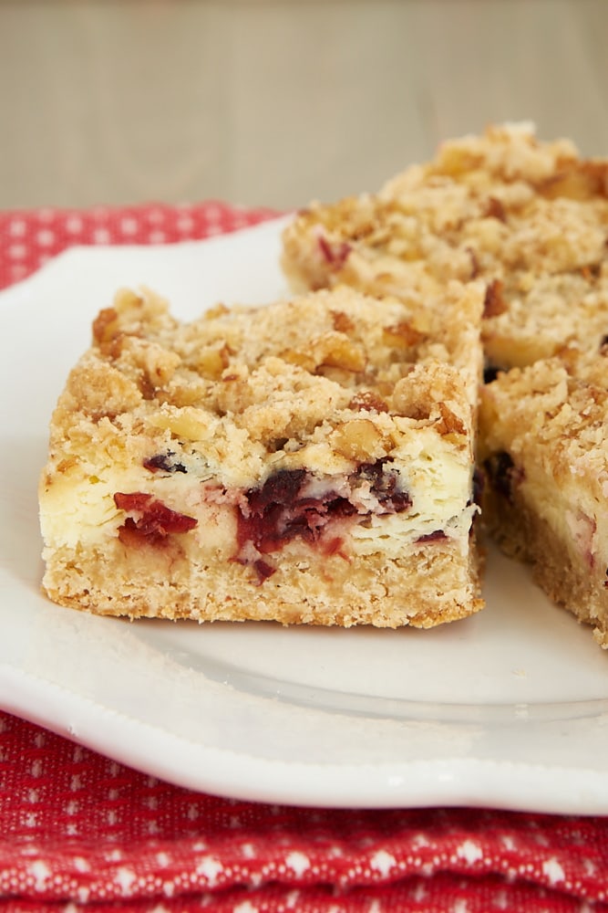 Cranberry Crumble Cheesecake Bars on a white plate