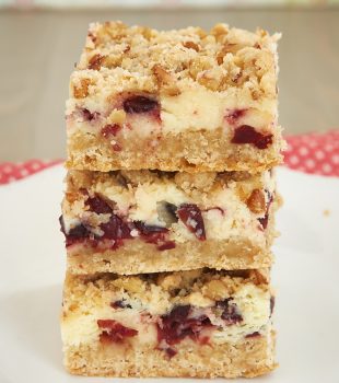 stack of Cranberry Crumble Cheesecake Bars on a white plate