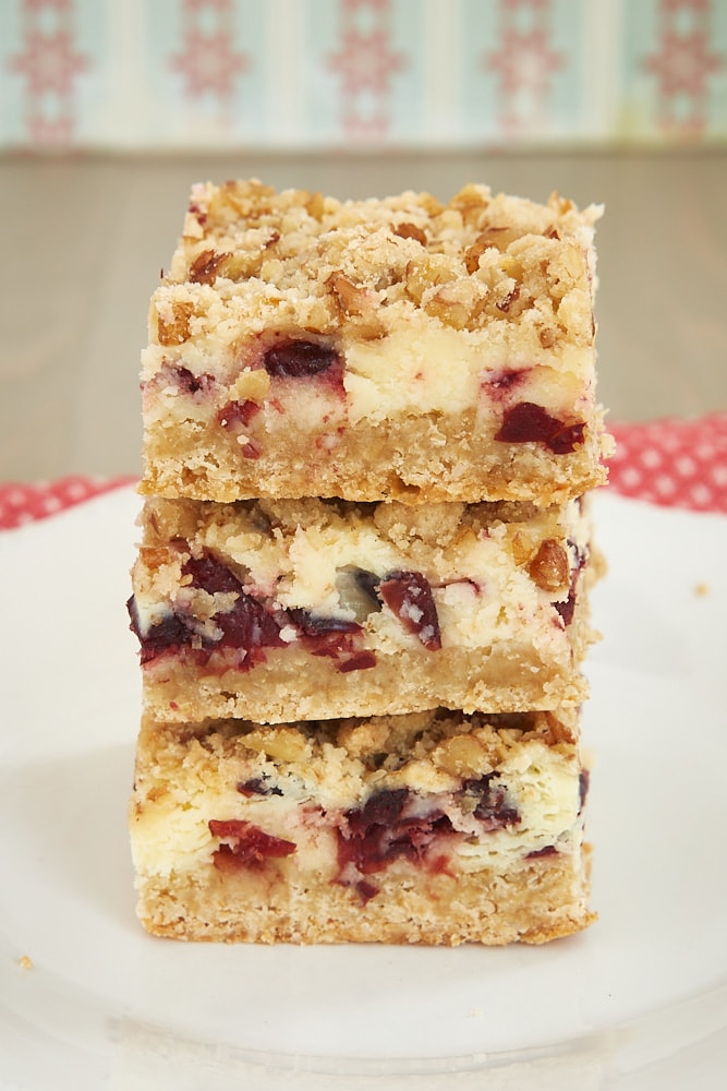 stack of Cranberry Crumble Cheesecake Bars on a white plate