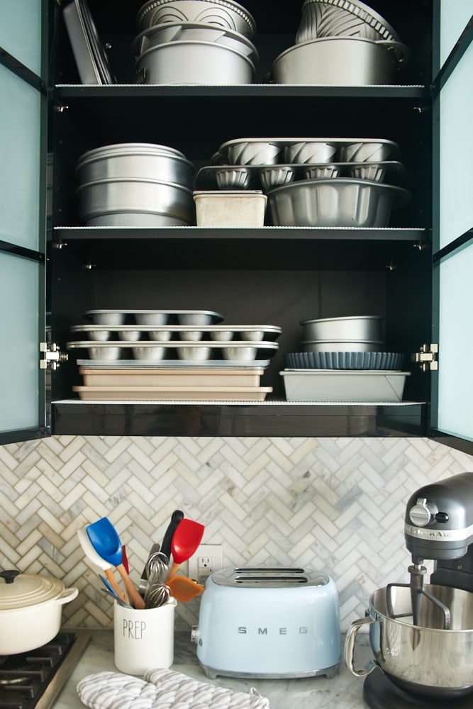 baking pans organized in a kitchen cabinet