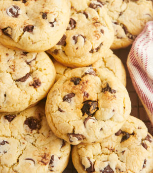 Pile of chocolate chip cookies with cherries.