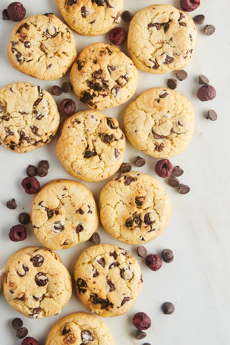 Cookies surrounded by chocolate chips and cherries.
