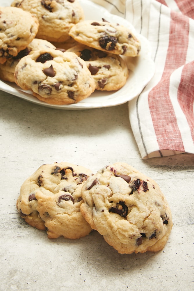 two Cherry Chocolate Chip Cookies on a gray surface