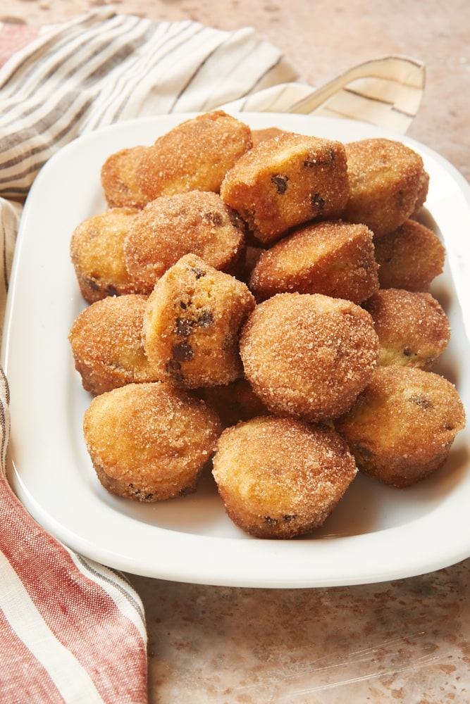 Mini Chocolate Chip Doughnut Muffins piled on a white tray