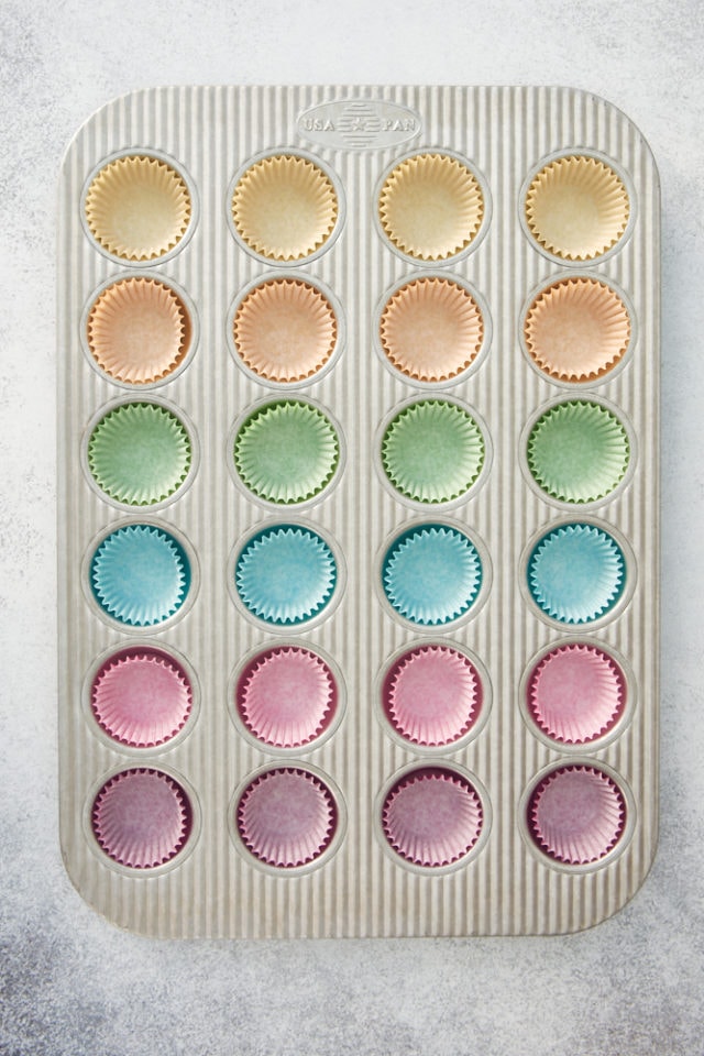 overhead view of different color cupcake liners in a mini muffin pan