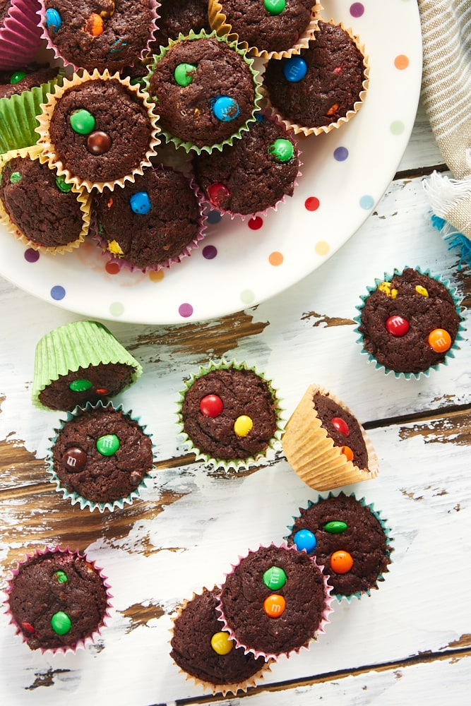 M&M Brownie Bites on a multi-colored polka dot plate and on a white wooden surface