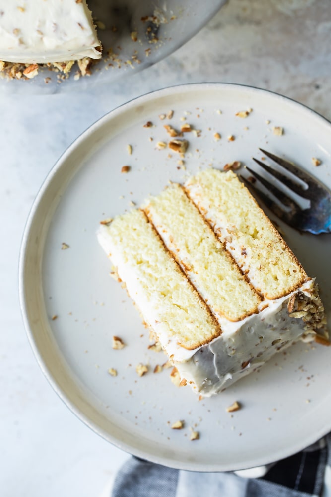 overhead view of a slice of Butter Pecan Cake on a beige plate