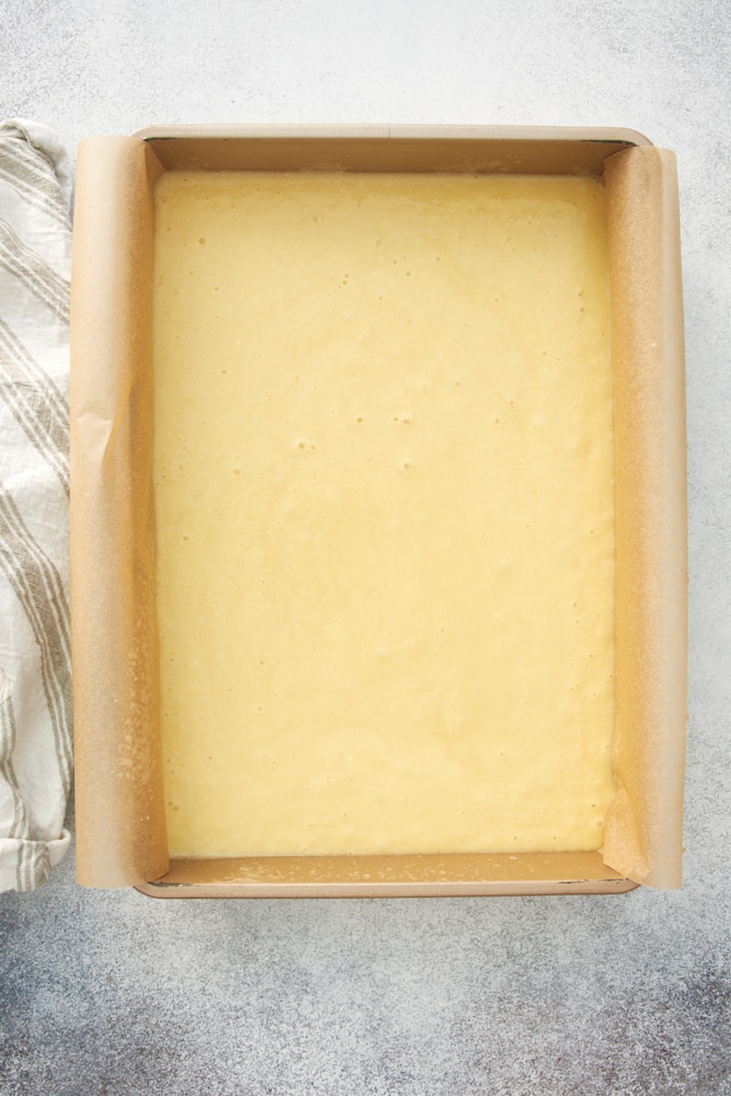 Overhead view of cake batter in parchment-lined baking pan